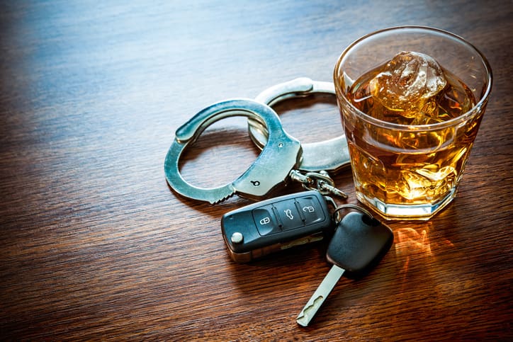 Whiskey with car keys and handcuffs concept for drinking and driving