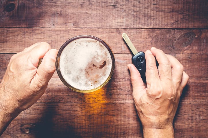 Man hand drinking beer and holding car keys